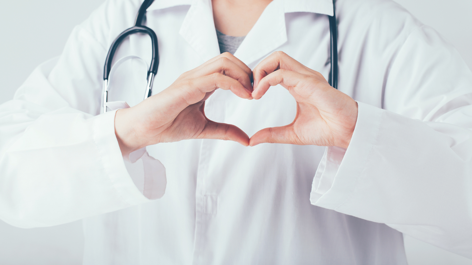 Close-up of a healthcare professional forming a heart shape to represent care and support during recovery